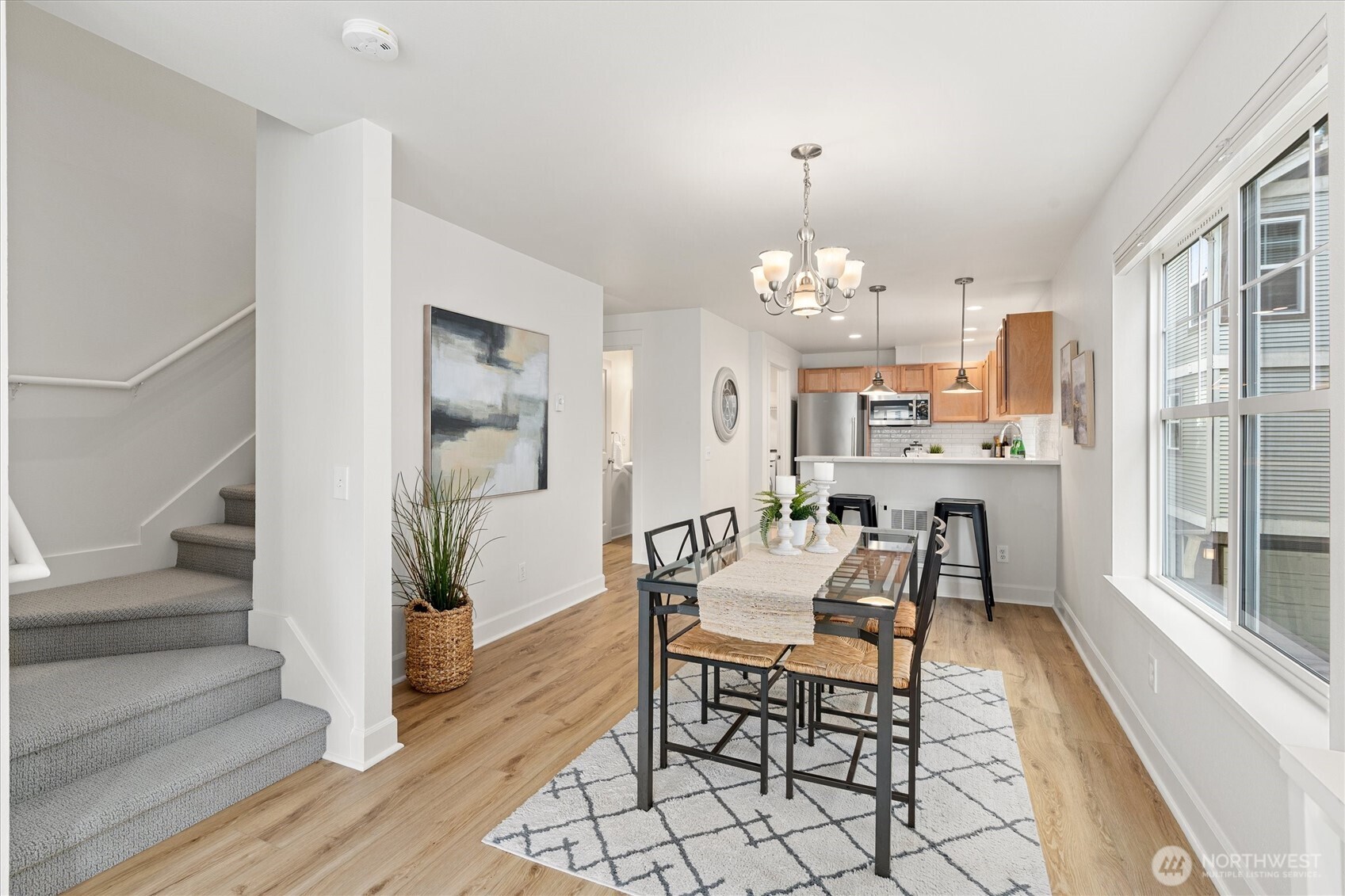 10311 Midvale Avenue North, Unit A Seattle, WA 98133 - Photo 3 of 19 a dining room with wooden floor and large windows
