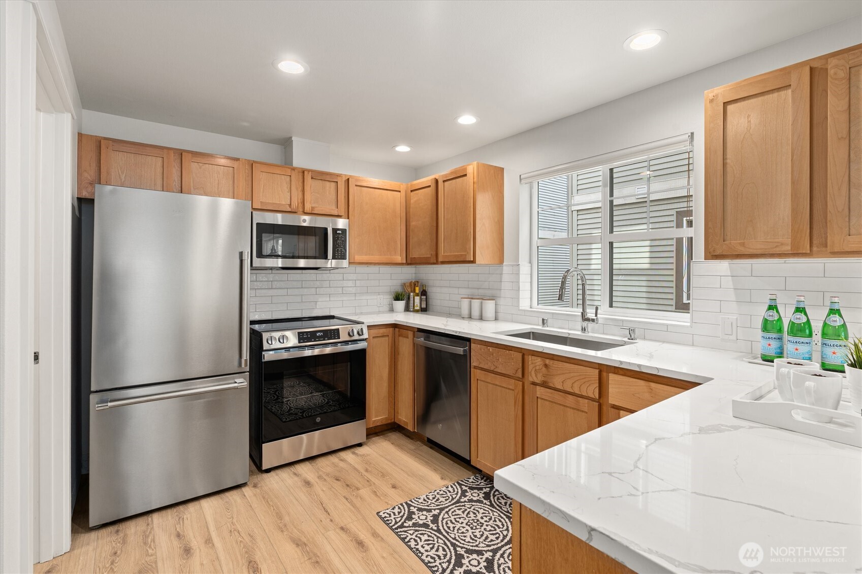 10311 Midvale Avenue North, Unit A Seattle, WA 98133 - Photo 4 of 19 a kitchen with stainless steel appliances granite countertop a refrigerator sink and microwave