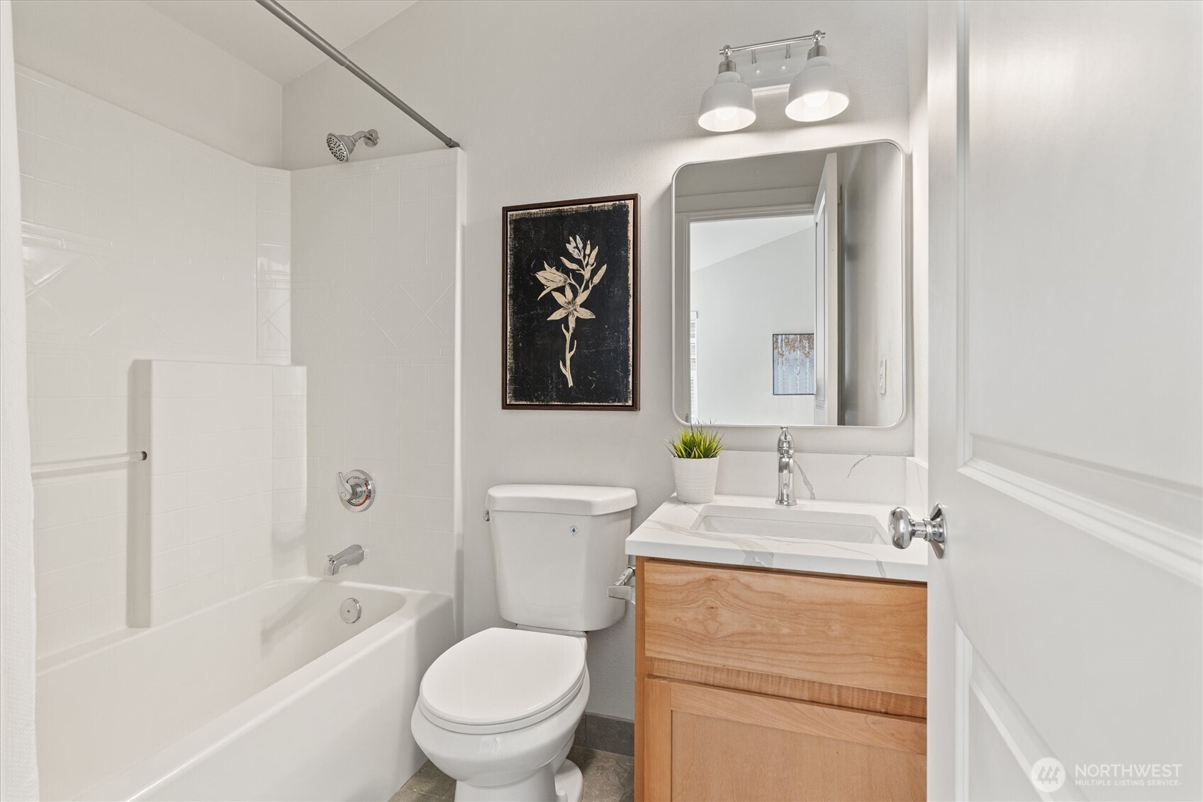 10311 Midvale Avenue North, Unit A Seattle, WA 98133 - Photo 10 of 19 a bathroom with a toilet a sink a tub and mirror