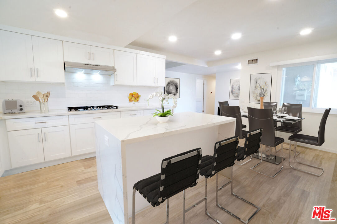 8251 Acacia Street Cypress, CA 90630 - Photo 3 of 13 a kitchen with a sink a stove and chairs