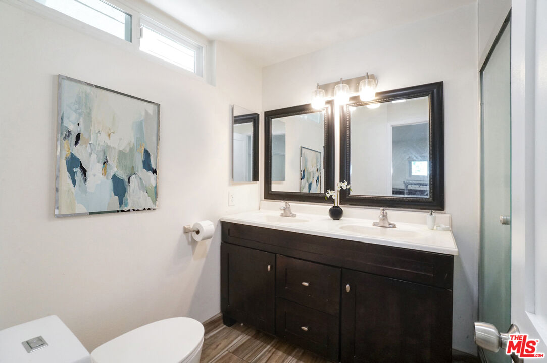 8251 Acacia Street Cypress, CA 90630 - Photo 6 of 13 a bathroom with a toilet a sink and mirror
