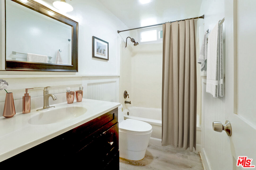 8251 Acacia Street Cypress, CA 90630 - Photo 10 of 13 a bathroom with a sink a toilet a mirror and shower