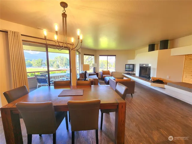 a dining room with furniture a chandelier and wooden floor