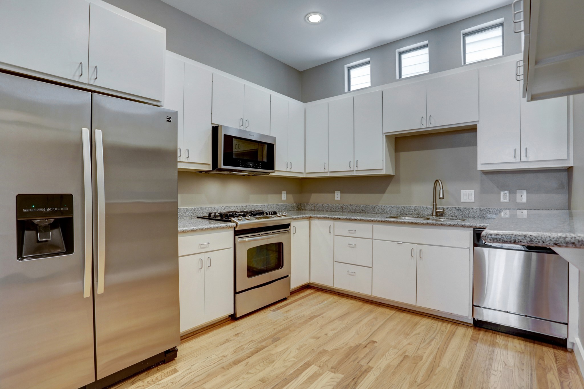 7650 Springhill Street, Unit 304 Houston, TX 77021 - Photo 2 of 18 a kitchen with cabinets stainless steel appliances and wooden floor
