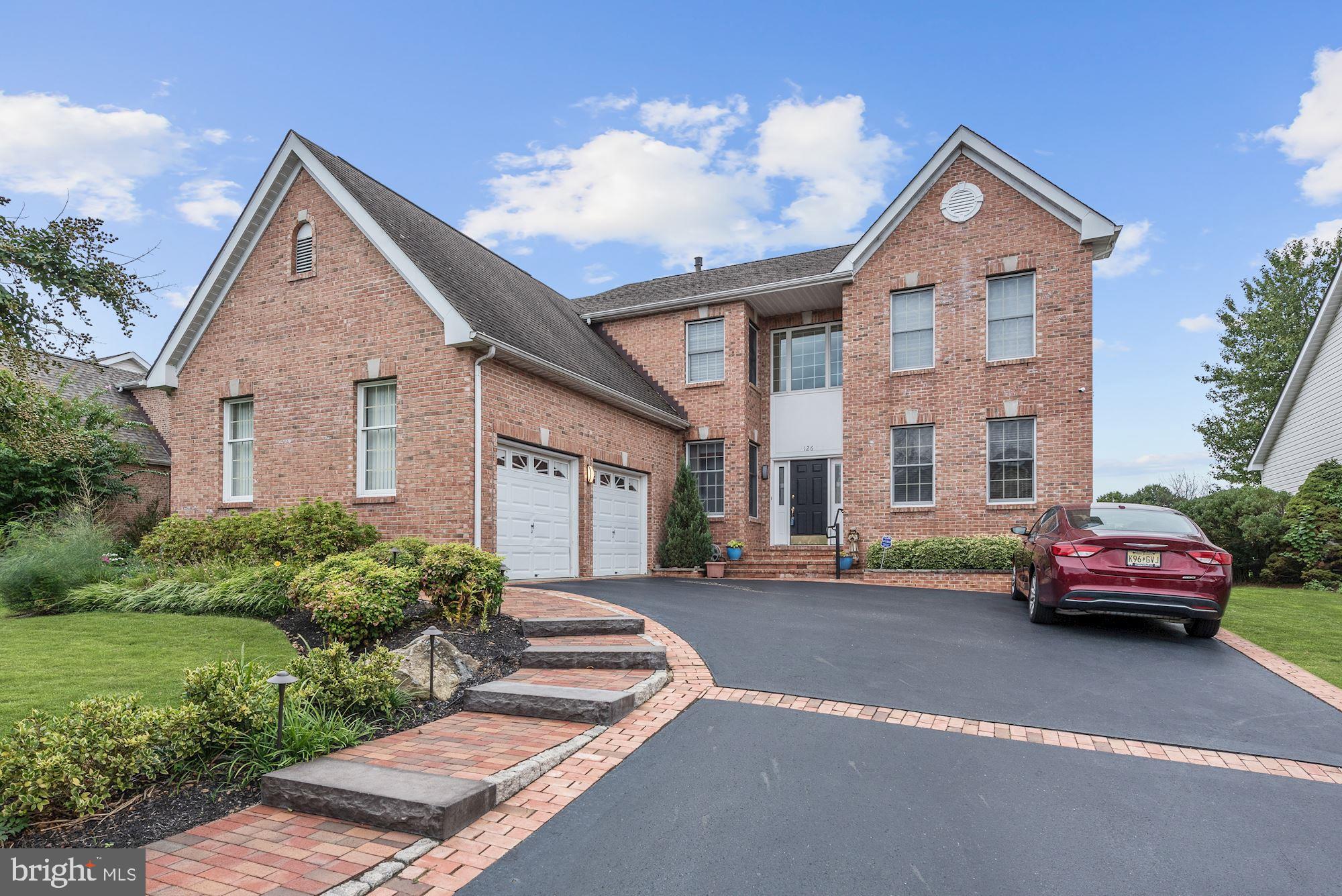 a front view of a house with a garden and parking