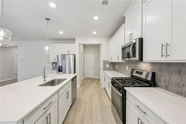 a kitchen with stainless steel appliances a sink stove and cabinets