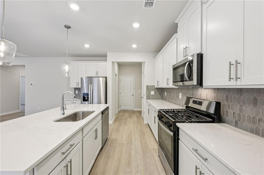 471 Tallulah Lane Grayson, GA 30017 - Photo 11 of 38 a kitchen with kitchen island granite countertop a sink a counter space stainless steel appliances and cabinets