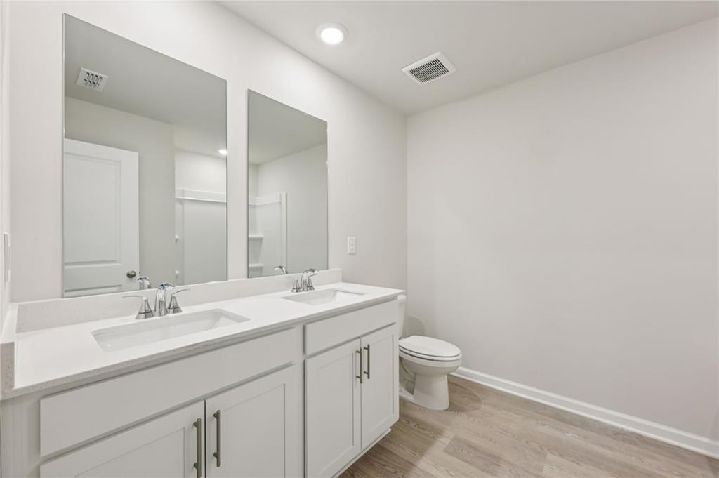 471 Tallulah Lane Grayson, GA 30017 - Photo 31 of 38 a bathroom with a double vanity sink toilet and a mirror