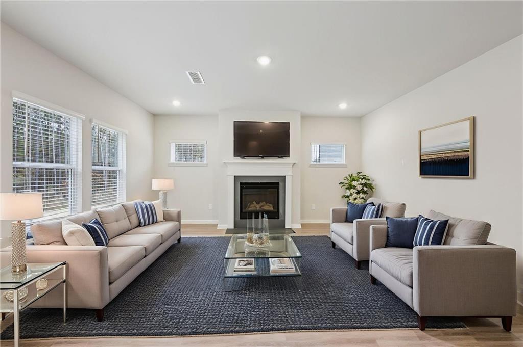 471 Tallulah Lane Grayson, GA 30017 - Photo 6 of 38 a living room with furniture a flat screen tv and a fireplace