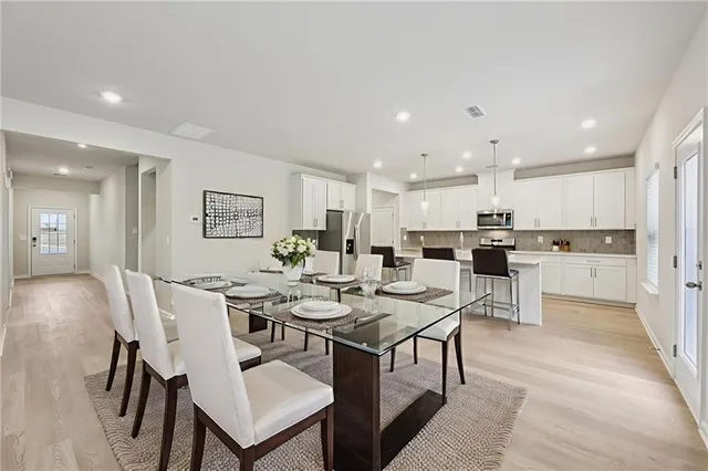 a large white kitchen with kitchen island a sink a center island stainless steel appliances and a cabinets