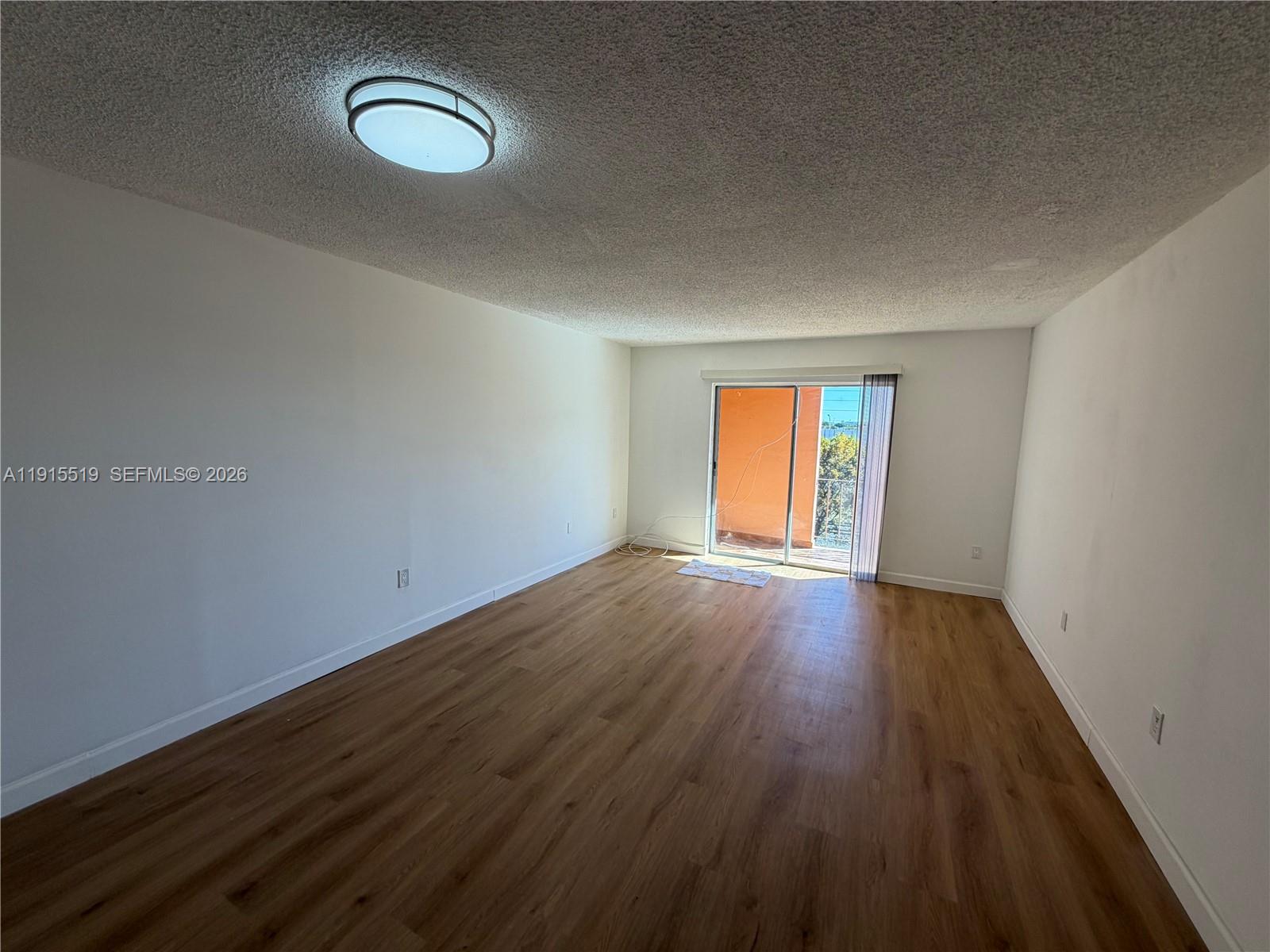 440 East 23rd Street, Unit 1305 Hialeah, FL 33013 - Photo 12 of 15 a view of an empty room with wooden floor and window