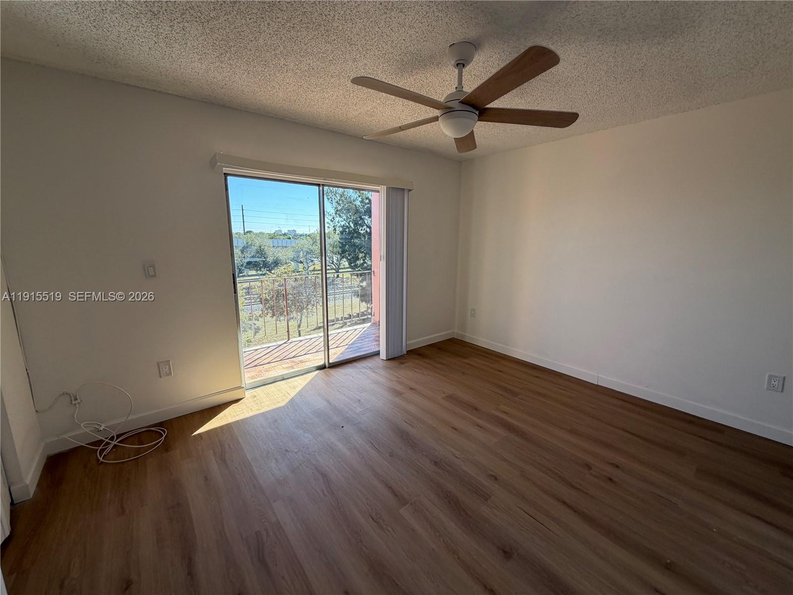 440 East 23rd Street, Unit 1305 Hialeah, FL 33013 - Photo 7 of 15 an empty room with wooden floor fan and windows