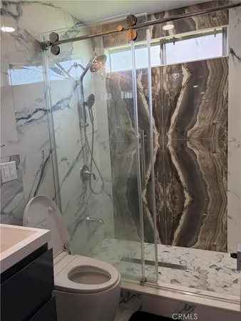 a bathroom with a granite countertop sink toilet and shower