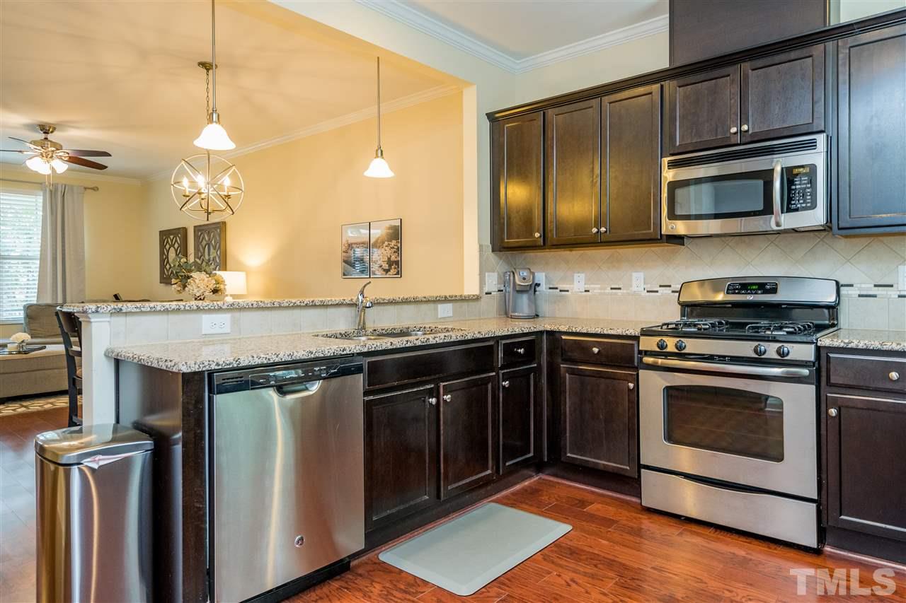 1547 Crafton Way Raleigh, NC 27607 - Photo 11 of 27 a kitchen with stainless steel appliances granite countertop a stove a sink and a microwave