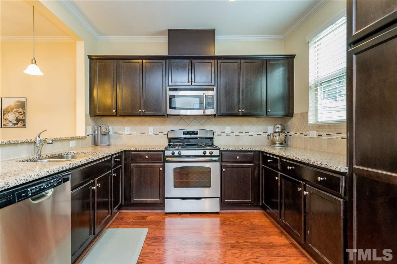 1547 Crafton Way Raleigh, NC 27607 - Photo 12 of 27 a kitchen with a sink stove and cabinets