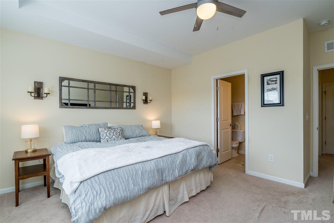 1547 Crafton Way Raleigh, NC 27607 - Photo 18 of 27 a bedroom with a bed and a chandelier