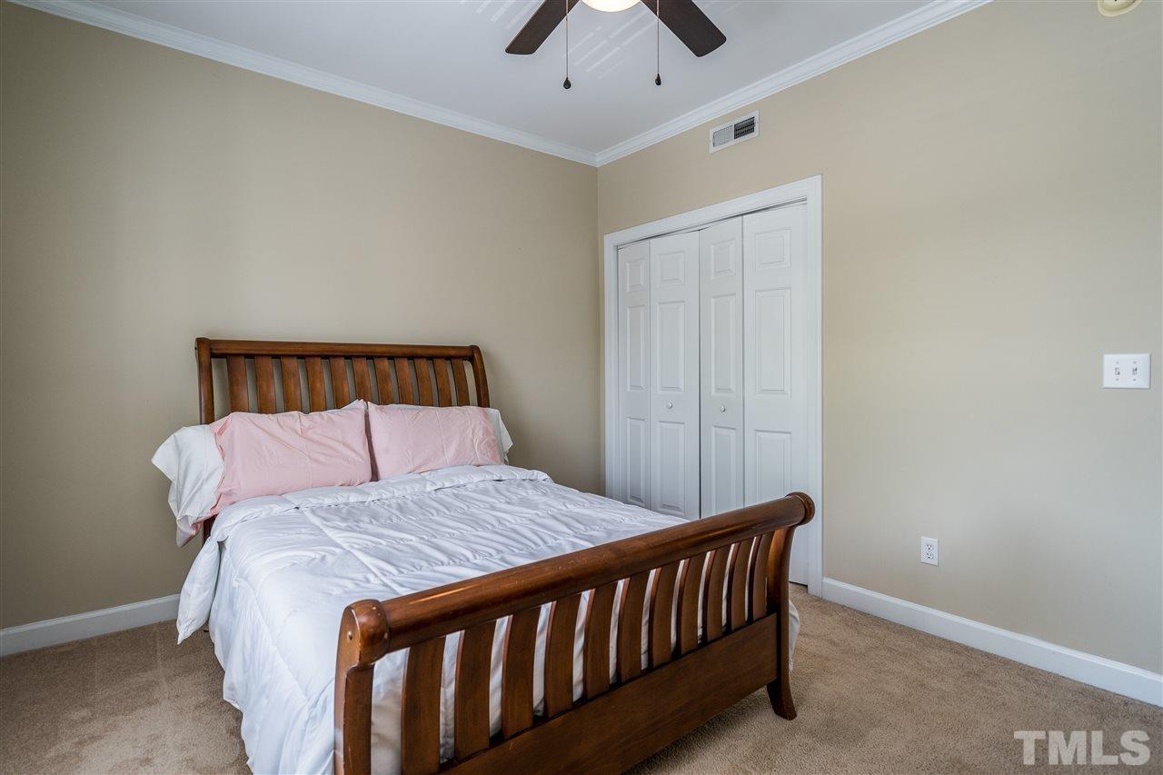 7016 Sandy Forks Road, Unit 201 Raleigh, NC 27615 - Photo 22 of 28 a bedroom with a bed and a chandelier