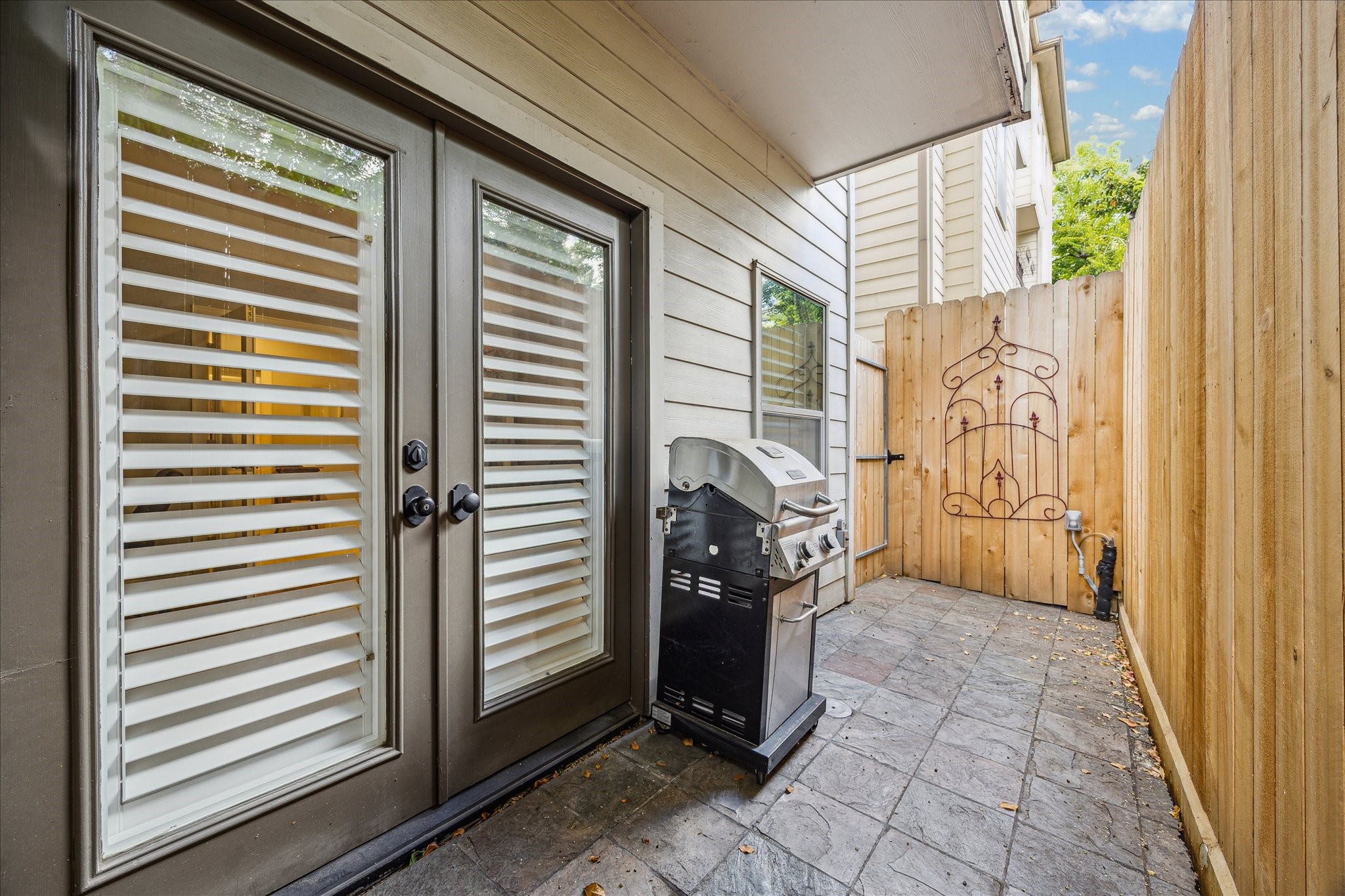 544 Bomar Street Houston, TX 77006 - Photo 15 of 43 OUTDOOR PATIO... Accessible directly from the first-floor bedroom/study, this inviting outdoor retreat features elegant paved slate flooring and a newly installed privacy wood fence—perfect for relaxing or entertaining with al fresco dining and outdoor grilling.