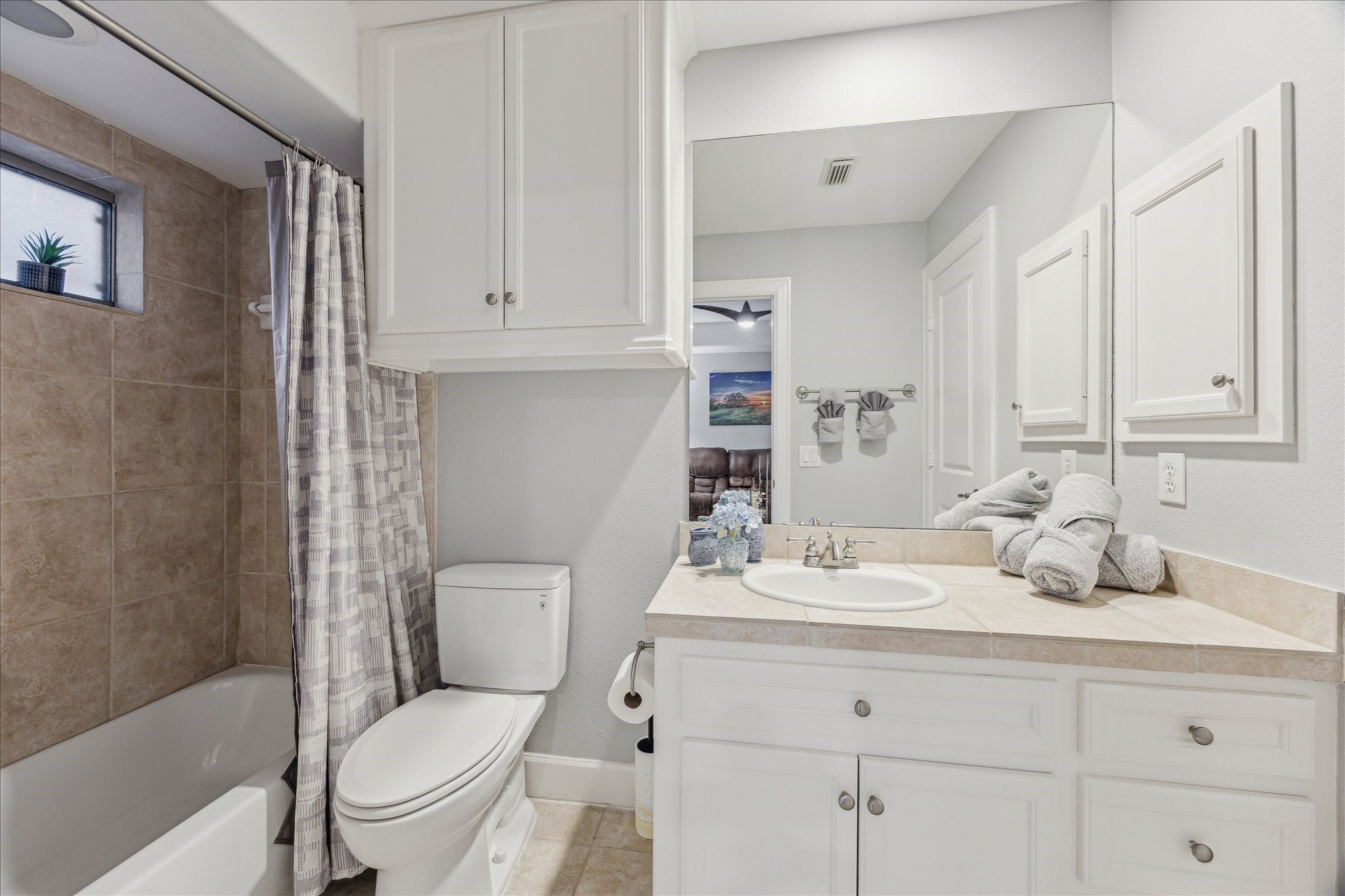 544 Bomar Street Houston, TX 77006 - Photo 15 of 43 ENSUITE BATH... An additional view reveals an oversized mirror and recessed lighting that enhance the room’s brightness and functionality. A built-in medicine cabinet offers added storage, and a convenient doorway provides direct access to the spacious walk-in closet.