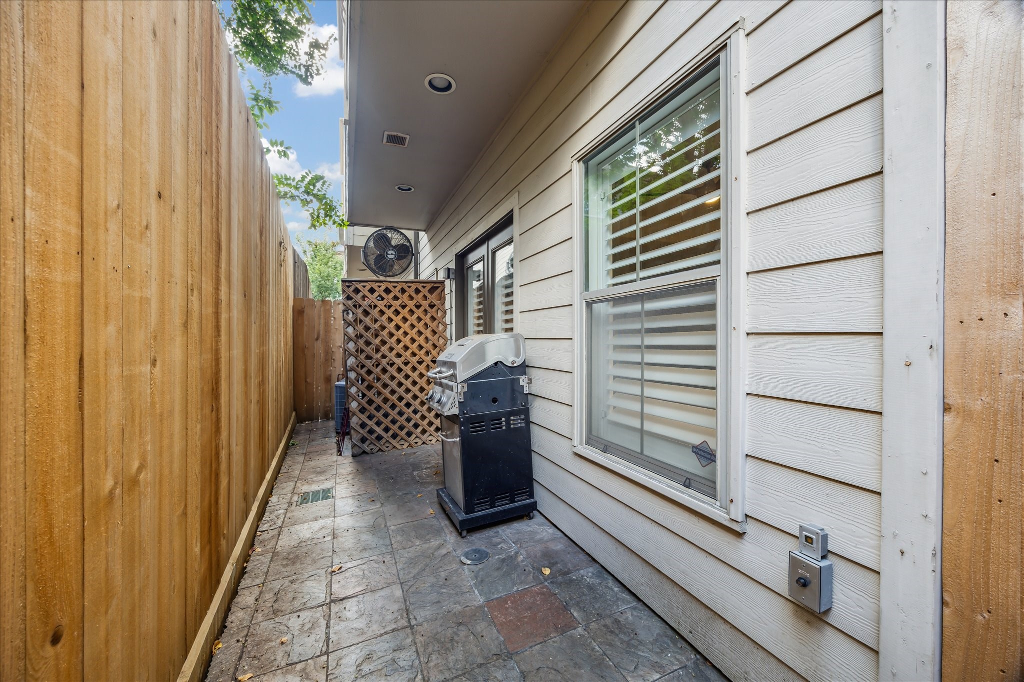 544 Bomar Street Houston, TX 77006 - Photo 16 of 43 OUTDOOR PATIO... A second view of this charming outdoor space showcases the beautifully paved slate flooring and the newly installed privacy wood fence. This area offers an ideal setting for outdoor dining, grilling, or simply enjoying a quiet moment in the fresh air.
