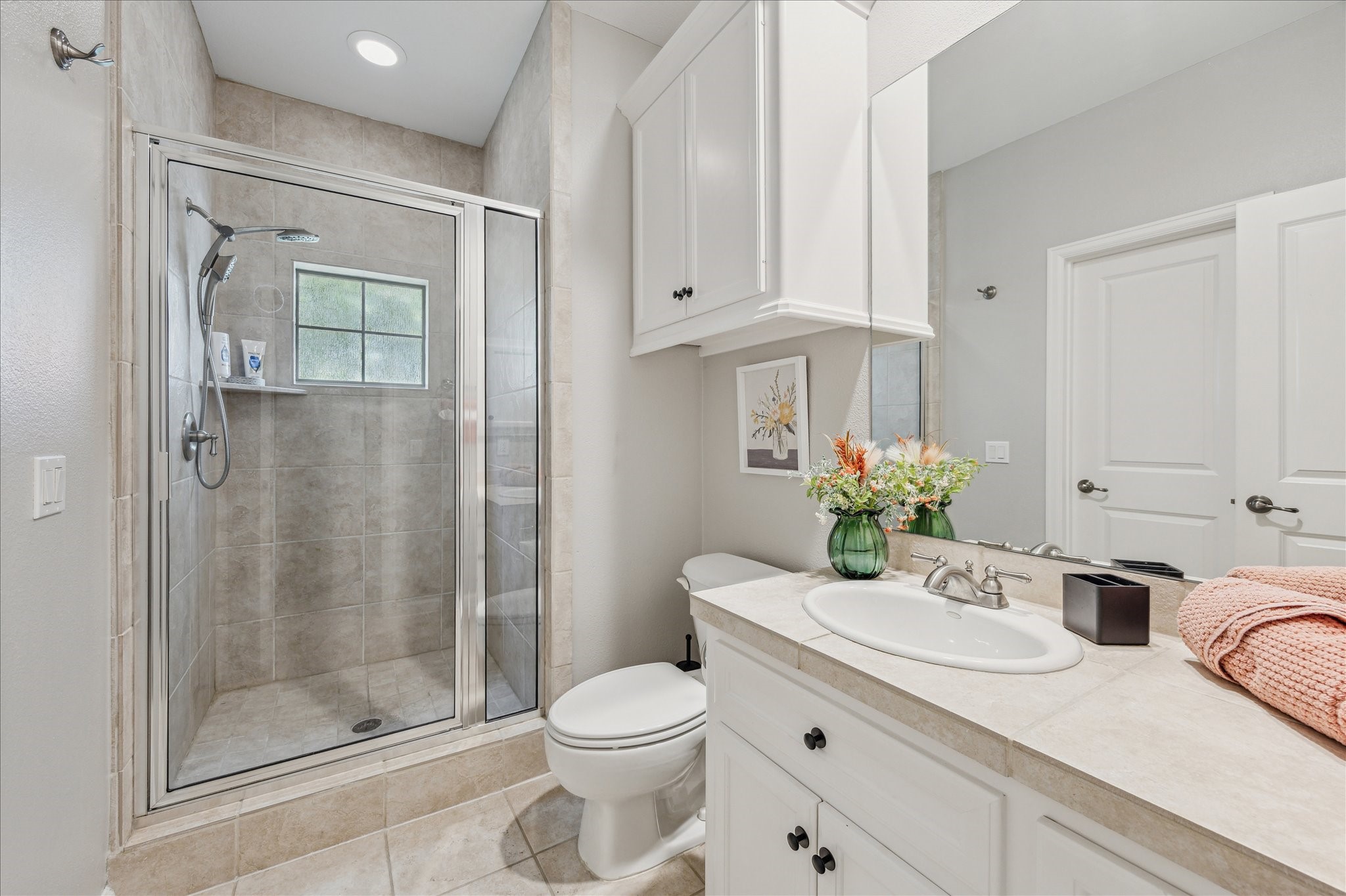 544 Bomar Street Houston, TX 77006 - Photo 40 of 43 An additional view reveals an oversized mirror, recessed lighting, and a built-in medicine cabinet that enhances both style and storage. The bath also offers direct access to a spacious walk-in closet, adding convenience and functionality to this private guest retreat.