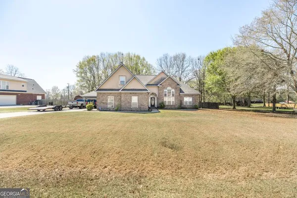 a front view of a house with a yard and fountain