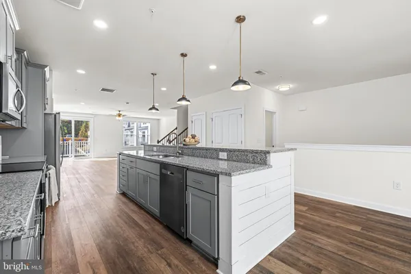 a kitchen with a sink stove and wooden floor