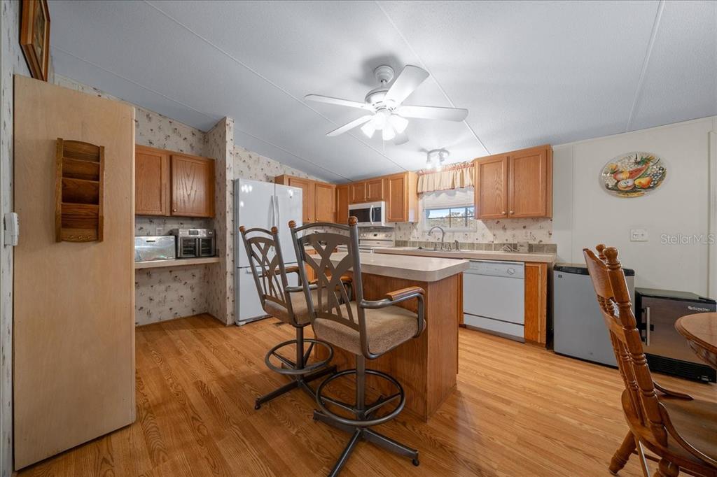 19189 Southwest 29th Street Dunnellon, FL 34432 - Photo 19 of 34 a kitchen with stainless steel appliances a table chairs refrigerator and microwave