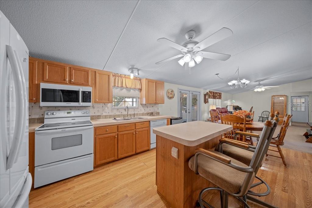 19189 Southwest 29th Street Dunnellon, FL 34432 - Photo 21 of 34 a kitchen with a stove a sink dishwasher a refrigerator with a dining table and chairs