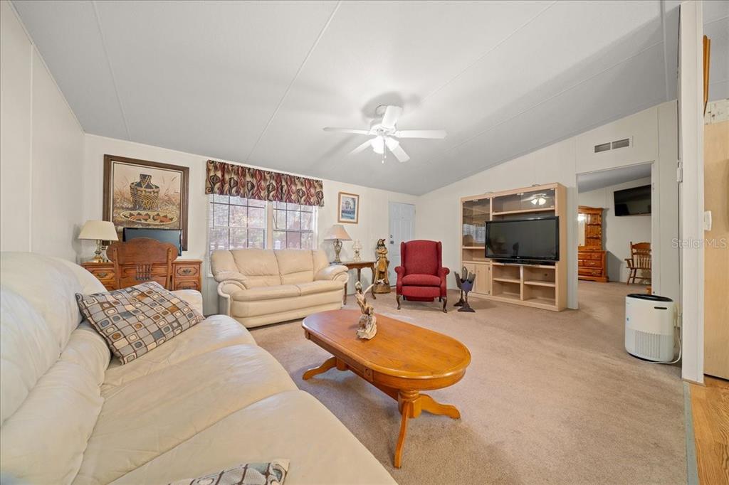 19189 Southwest 29th Street Dunnellon, FL 34432 - Photo 24 of 34 a living room with furniture a flat screen tv and kitchen view