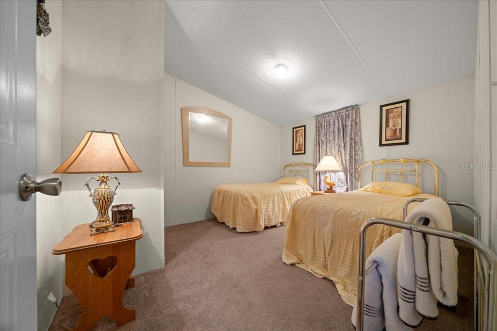 19189 Southwest 29th Street Dunnellon, FL 34432 - Photo 31 of 34 a bedroom with two beds and a lamp