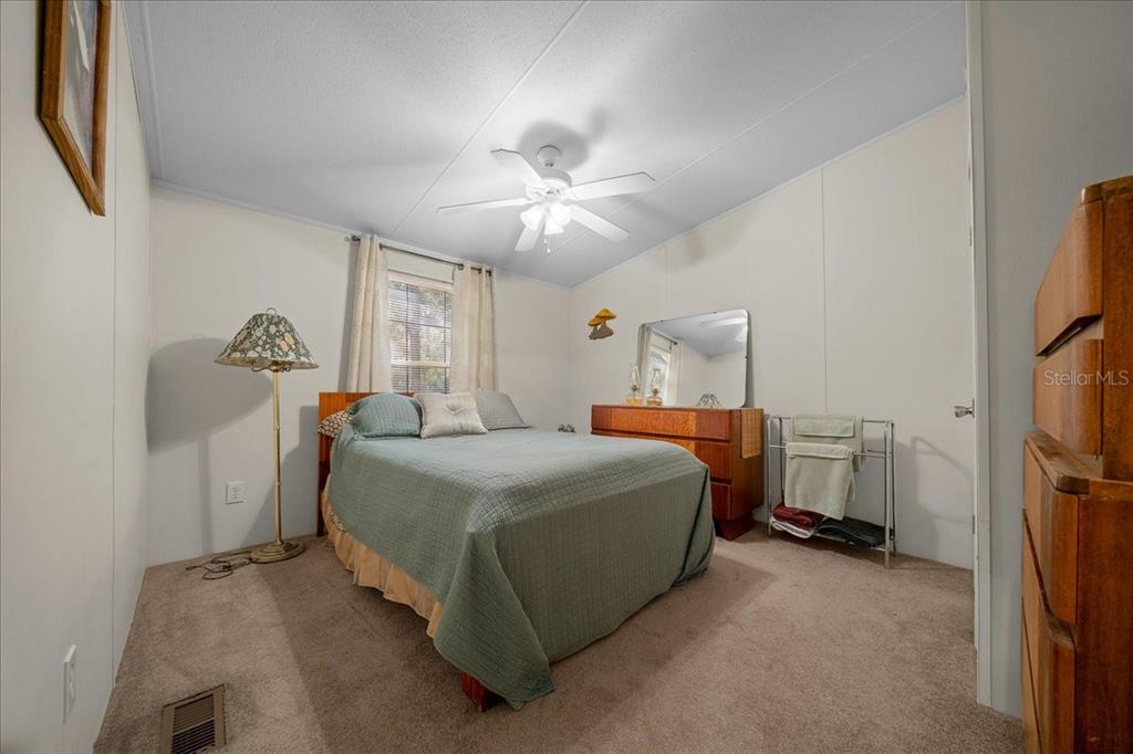 19189 Southwest 29th Street Dunnellon, FL 34432 - Photo 32 of 34 a bedroom with a bed and a chandelier