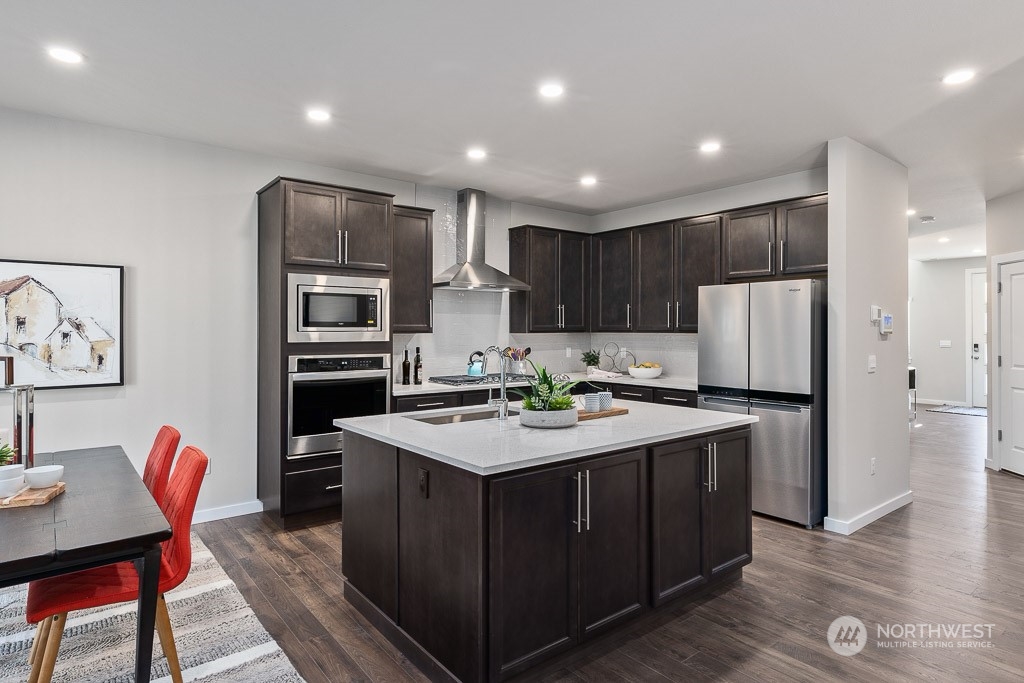 21441 Royal Anne Road Bothell, WA 98021 - Photo 7 of 29 a kitchen with kitchen island a refrigerator stove a sink and a oven with wooden floor