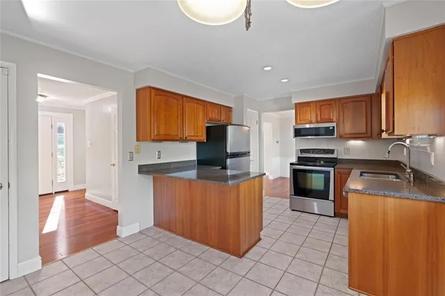 a kitchen with granite countertop a refrigerator and a stove top oven