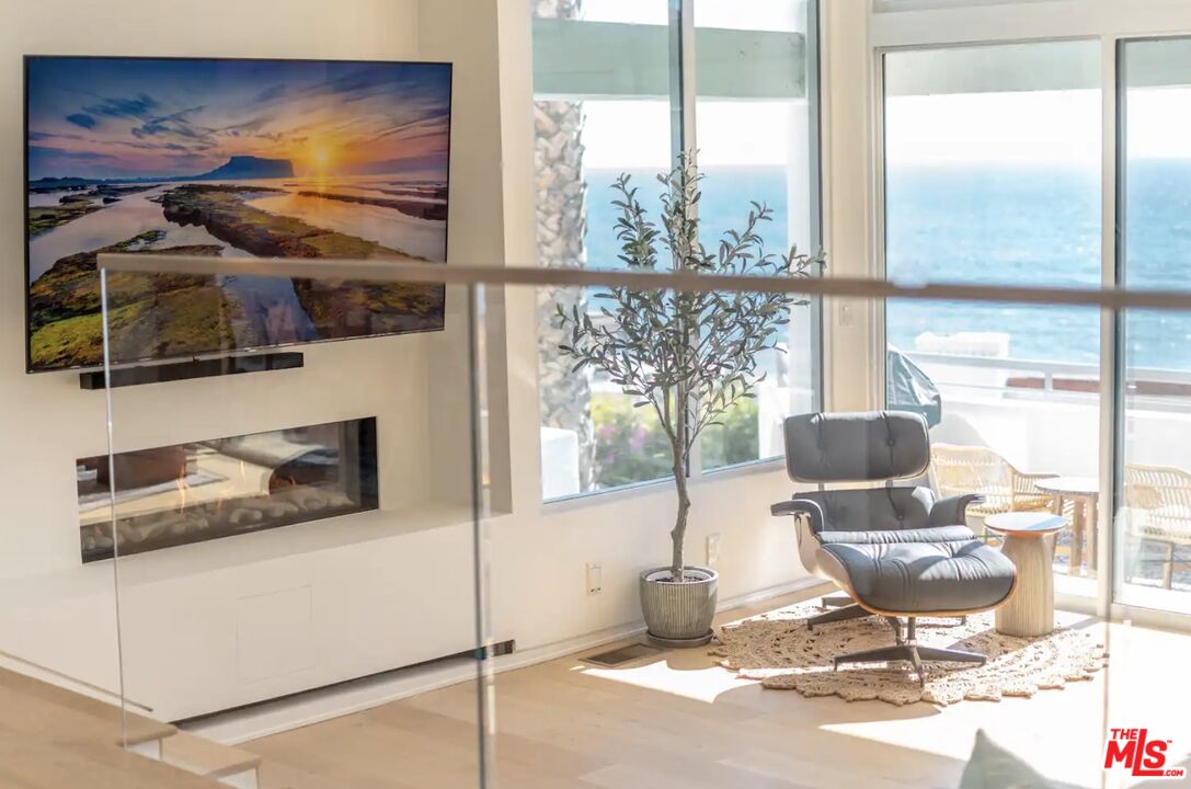 21349 Rambla Vista Malibu, CA 90265 - Photo 12 of 16 a living room with a floor to ceiling window and a flat screen tv