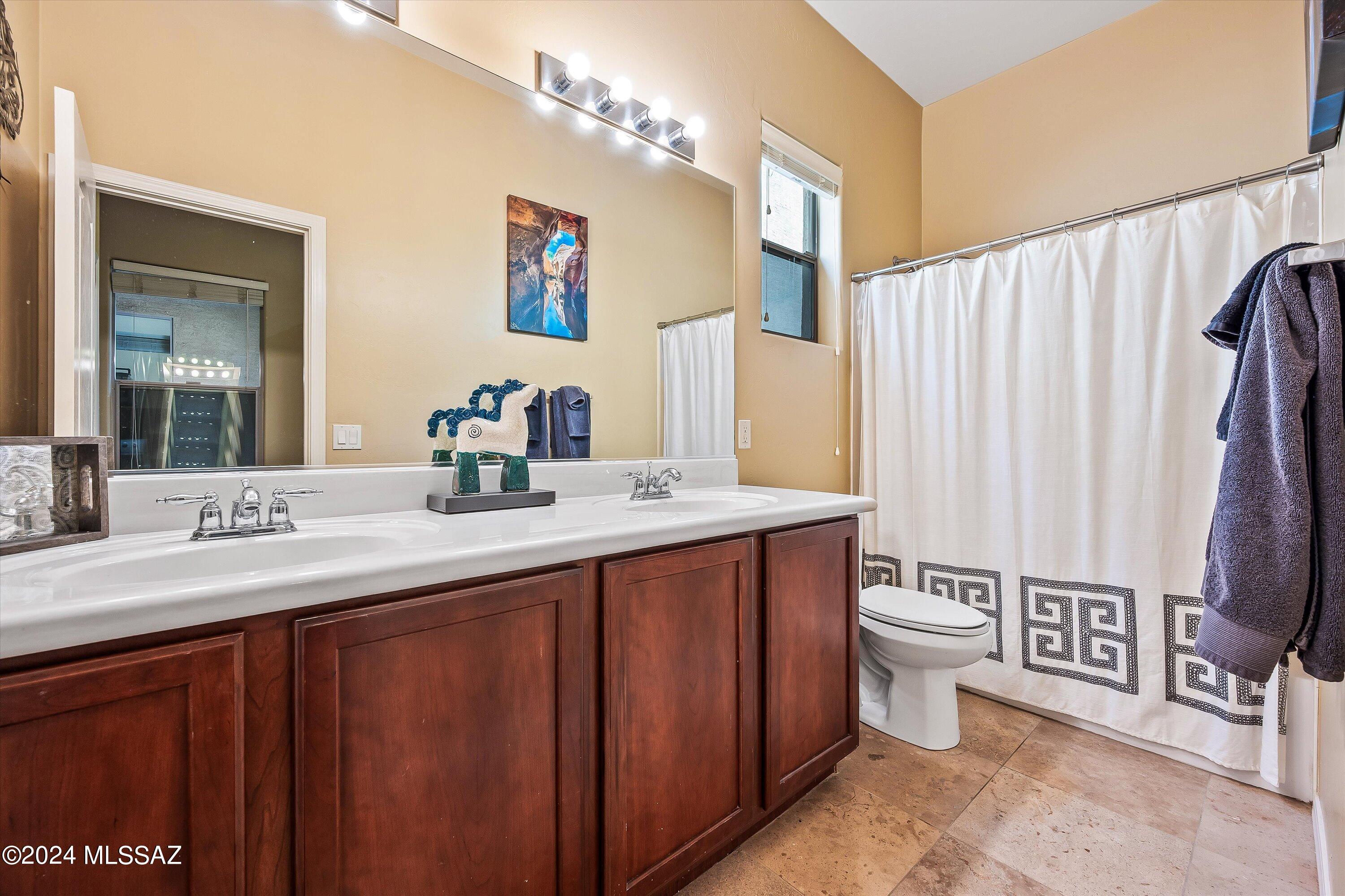 8579 North Shadow Wash Way Tucson, AZ 85743 - Photo 18 of 34 a bathroom with a granite countertop sink toilet and a mirror