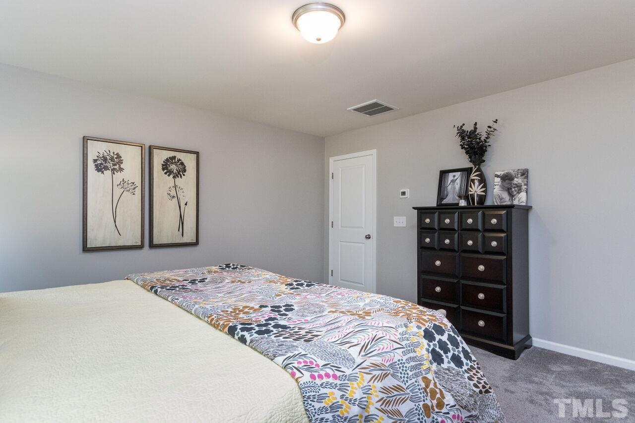 1109 Sandtrap Way Durham, NC 27703 - Photo 14 of 35 a bedroom with a bed and a dresser