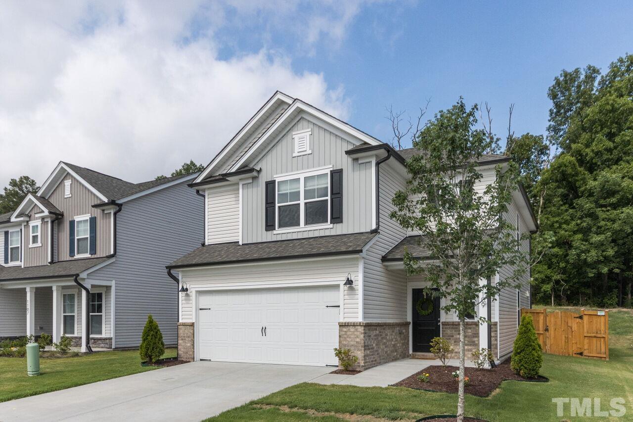 1109 Sandtrap Way Durham, NC 27703 - Photo 2 of 35 a front view of a house with a yard and garage