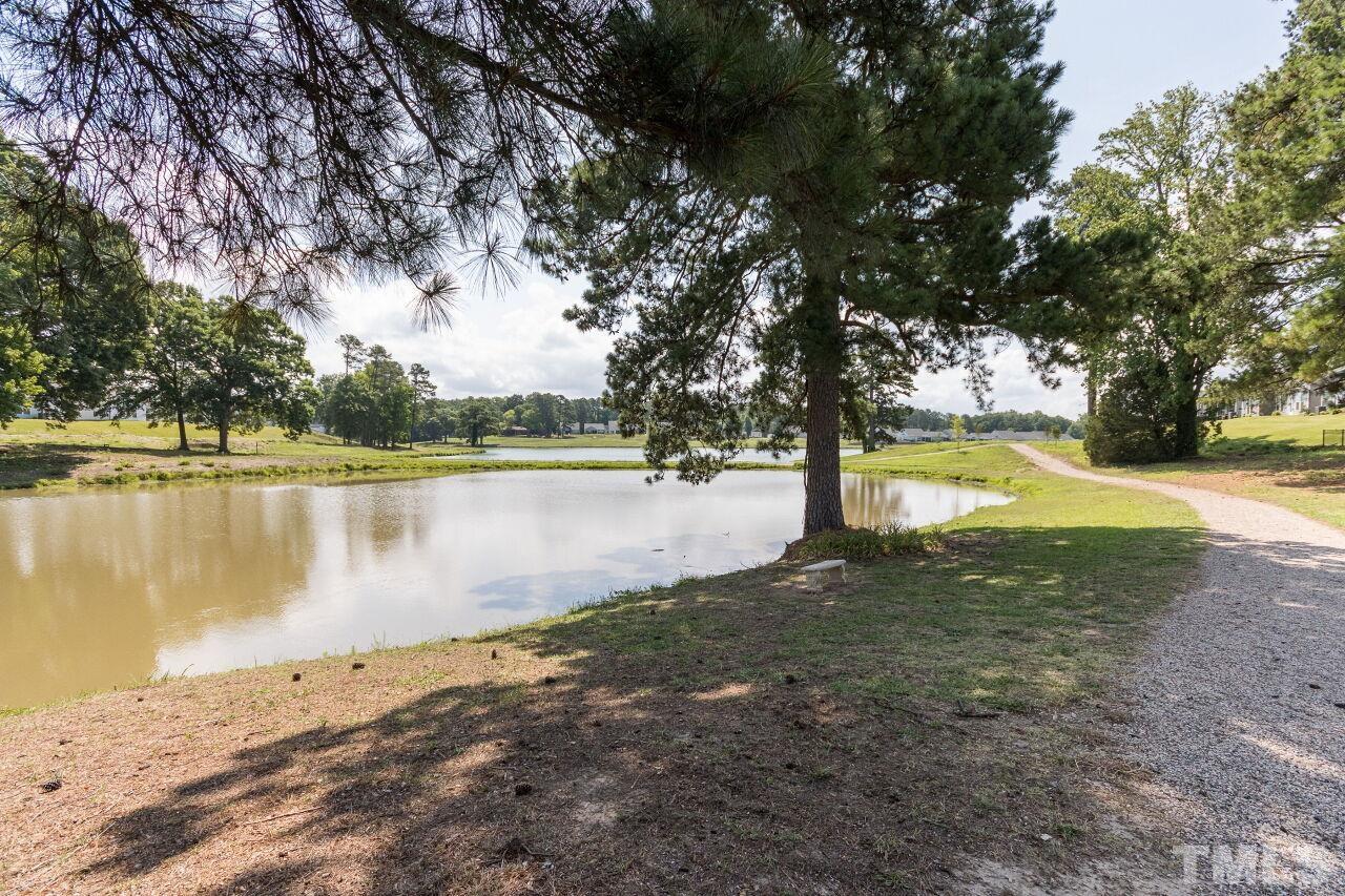 1109 Sandtrap Way Durham, NC 27703 - Photo 34 of 35 a view of a lake with a yard and large trees