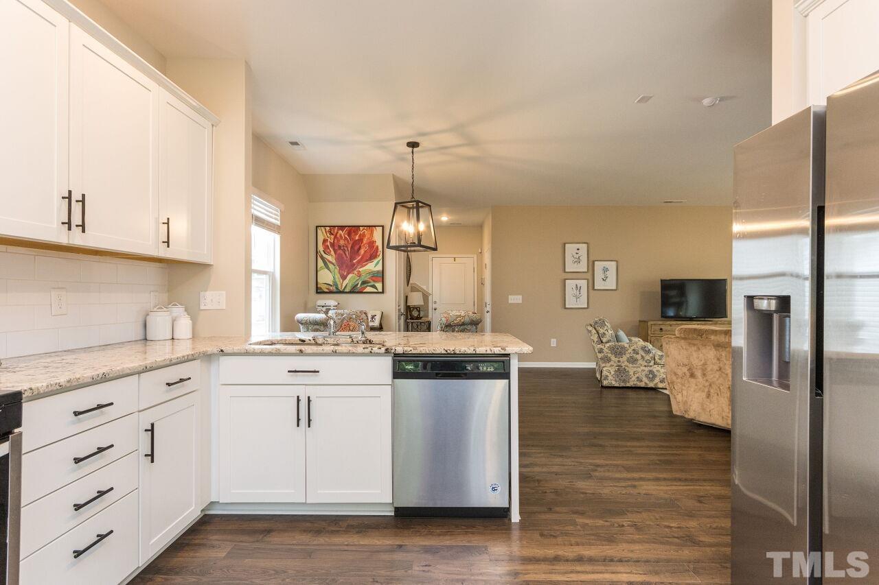 1109 Sandtrap Way Durham, NC 27703 - Photo 9 of 35 a kitchen with stainless steel appliances kitchen island granite countertop a sink and cabinets