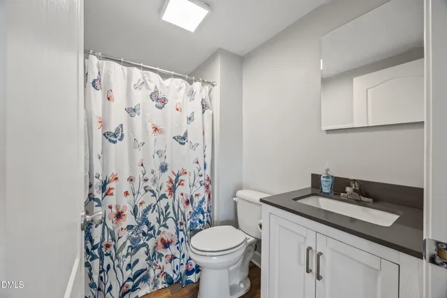 a bathroom with a granite countertop toilet sink and mirror