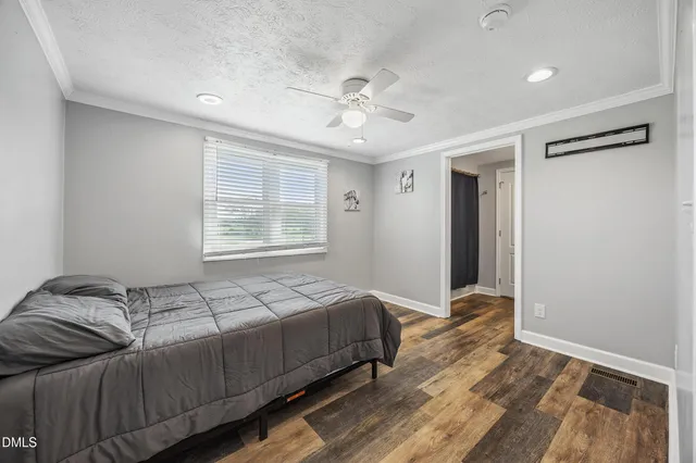 a bedroom with a bed and wooden floor