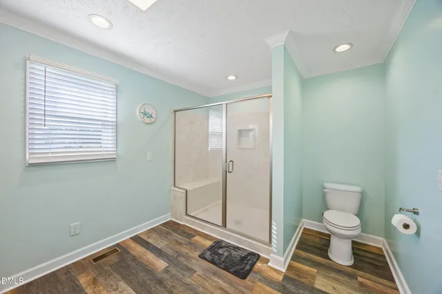 a bathroom with a toilet and a shower