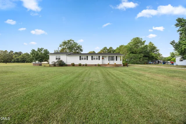 a view of house with garden space and car parked