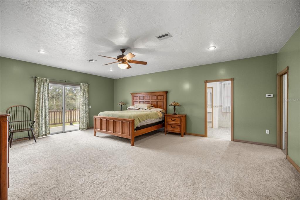 4559 West Dunklin Street Dunnellon, FL 34433 - Photo 14 of 65 a spacious bedroom with a bed and a chandelier