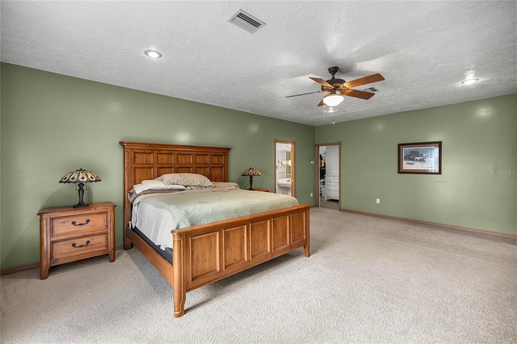 4559 West Dunklin Street Dunnellon, FL 34433 - Photo 15 of 65 a spacious bedroom with a bed and a ceiling fan