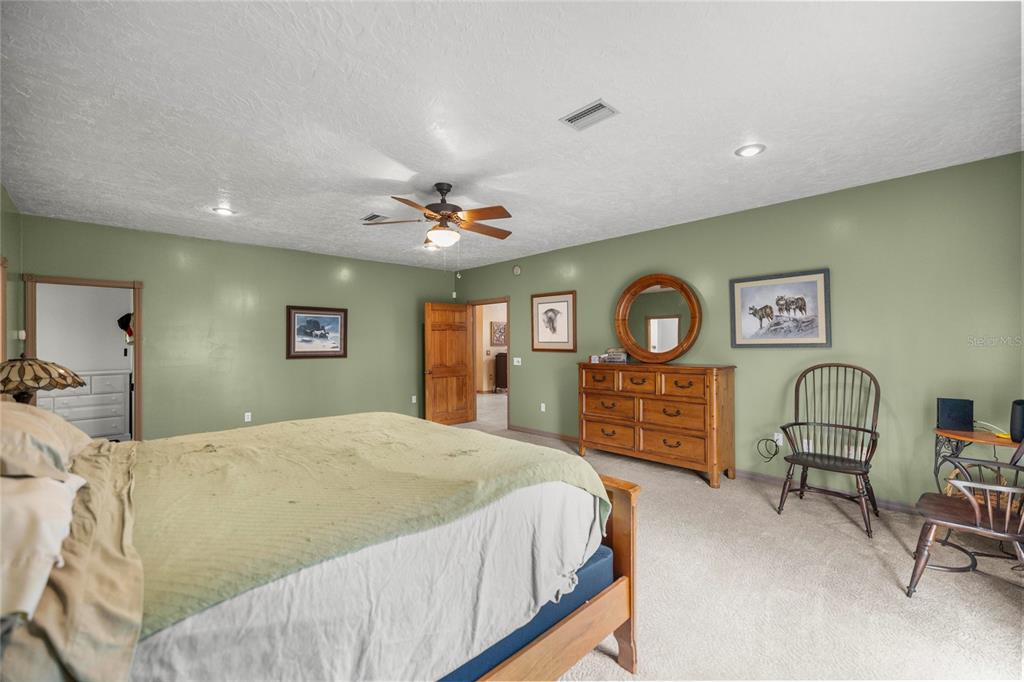 4559 West Dunklin Street Dunnellon, FL 34433 - Photo 16 of 65 a bedroom with a bed a dresser and chair
