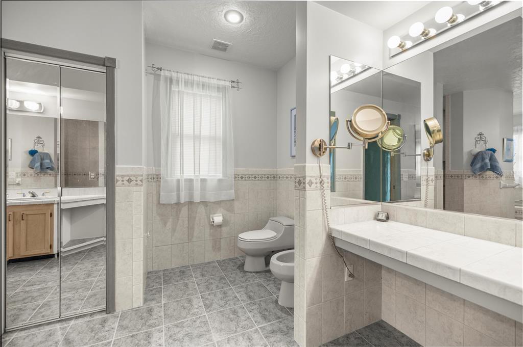 4559 West Dunklin Street Dunnellon, FL 34433 - Photo 19 of 65 a bathroom with a toilet a sink a tub and mirror