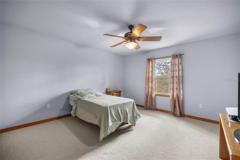 4559 West Dunklin Street Dunnellon, FL 34433 - Photo 24 of 65 a bedroom with a bed and a chandelier