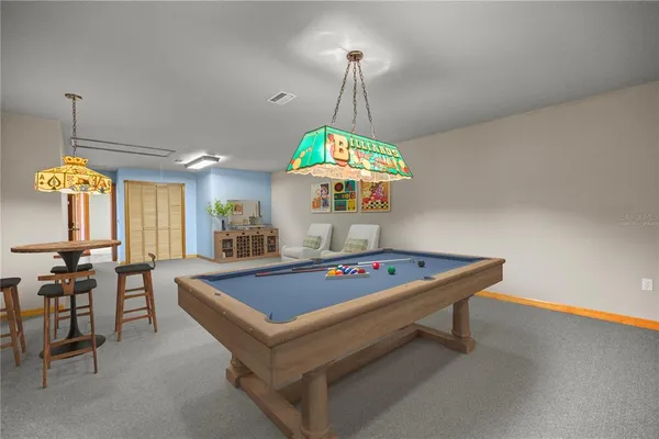 a view of an empty room with window and chandelier fan